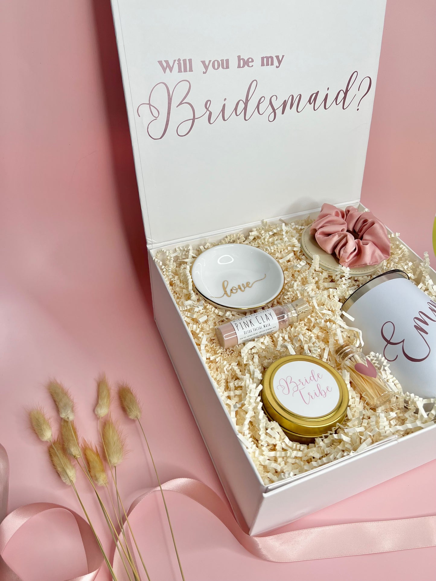 Personalized Bridesmaid Proposal box filled with rose, gold and white products. Contains travel size candle with custom sticker, satin scrunchie, pink clay face mask, compact mirror, ring dish, personalized 12oz tumbler, match jar with striker.